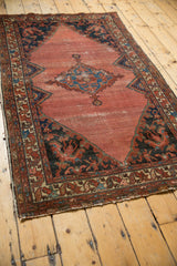 Bottom right corner of the vintage Malayer rug, highlighting the tattered edge and worn field.