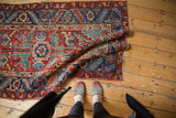 Vintage Heriz runner showing wide geometric border, red, teal, blue motifs, and low pile.