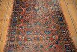 Vintage Heriz runner with madder red field, blue Herati motifs, low pile, and intact selvage.