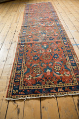Vintage Heriz runner's intricate Herati motif in madder red, navy blue, and ivory pile.