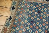Antique Kuba runner showing the tattered perimeter and geometric floral field in blue and rusty pink.
