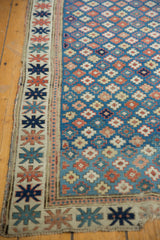 Antique Kuba runner detail: geometric border, tattered edge, and blue field with playful patterns.