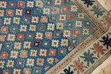 Kuba rug detail showing desirable blue geometric floral field and intricate star border.