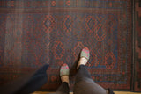 Antique Belouch rug's repeating medallion design in deep indigo and madder red.