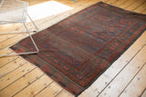 Antique Belouch rug featuring a repeating medallion design in time-softened deep indigo and madder red.