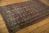 Antique Malayer rug corner with charcoal boteh field, intricate border, tattered selvage.