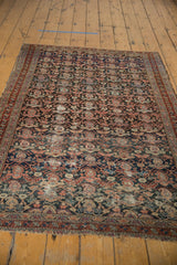 Intricate Malayer rug detail: charcoal, navy, blush boteh and vinery pattern with visible wear.