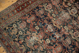Antique Malayer rug corner detail with dark field, intricate vinery, and aged pile.