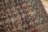 Antique Malayer rug's intricate allover boteh motif on charcoal, showing localized foundation wear and tattered selvage.