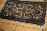 Antique Borchalou rug corner, showing ivory field, madder red florals, sky blue border, and tattered fringe.