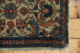 Antique Borchalou rug corner displaying worn madder red floral motifs and tattered fringe.