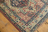 Intricate navy and mauve floral border detail on an antique Persian Kerman collector rug.