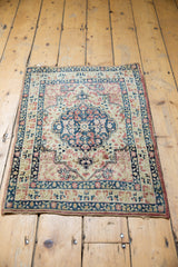 Angled overhead view of an antique Kerman rug's roundel medallion and floral field.
