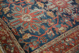 Vintage Heriz rug detail: intricate navy, red, and blue pattern, showing worn pile.