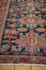 Vintage Heriz rug detail: intricate vinery in navy, cherry red, sky blue, and visible pile wear.