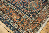 Hand-knotted Karaja rug corner, geometric border in copper terracotta, navy, and sky blue.