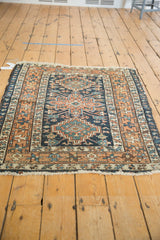 Lower right corner detail of vintage Karaja rug showcasing worn navy, terracotta, and sky blue geometric patterns.