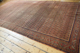 Allover boteh pattern in blush and charcoal, showing mostly even wear on an antique Malayer rug.