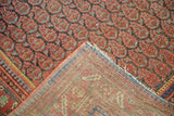 Exposed hand-knotted foundation and worn reddish-charcoal boteh pile of the antique Malayer carpet.