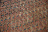 Antique Malayer carpet close-up: repeating boteh motif, blush, charcoal, blue, with visible foundation.