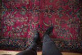 Vintage Lilihan rug with rich raspberry red field, sprawling floral vinery, navy border.