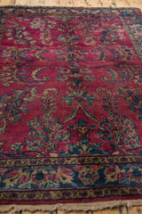 Detail of hand knotted Lilihan rug, dense raspberry red floral motifs and visible foundation.