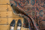 Vintage Lilihan rug's dusty rose and blue Herati motif with tattered, reinforced edge.