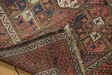 Intricate water channel border, fringed edge, and worn geometric gul motifs of Belouch runner.