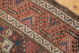 Vintage Belouch runner detail: worn madder red field with blue accents and pale water channel border.