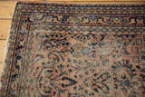 Lilihan rug detail: dusty blush field, inky blue scrolling vinery, floral motifs, geometric borders, mostly even wear.