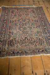 Secured end with tattered fringe, dark blue border of a vintage Lilihan rug.