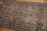 Vintage Lilihan rug's dusty blush field with navy vinery, floral motifs, and visible wear.