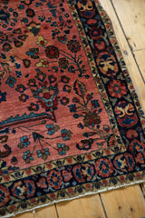 Vintage Mohajeran Sarouk rug corner, dusty raspberry floral field, low pile, and deep blue border.