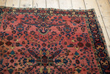Vintage Sarouk rug: dusty raspberry blush field, classic floral sprays, patterned border, low pile.
