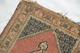 Vintage Tabriz rug corner detail highlighting navy floral spandrel and tattered fringe.