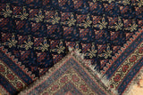 Hand-knotted weave on the reverse of an antique Belouch rug with tattered ends.