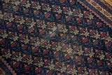 Antique Belouch rug's worn germinating flower motif field in navy, madder red, and ivory.