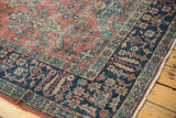Vintage Mahal carpet's indigo border displaying beige, blush, and blue delicate vinery.