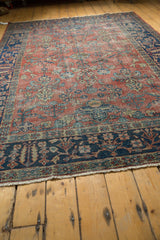 Vintage Mahal carpet lower corner showcasing indigo floral border and brick red field detail.