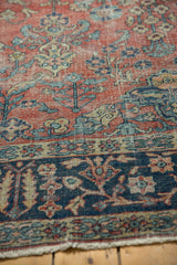 Brick red field of Vintage Mahal carpet with splayed blue floral motifs, showing mostly even wear.