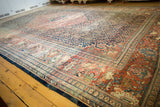 Antique traditional Farahan Sarouk carpet, ornate floral motifs in time-softened navy and terracotta hues.