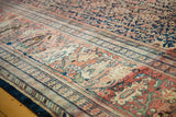 Storied antique Farahan Sarouk border, terra cotta palmettes, time-softened hues.