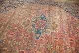 Scalloped medallion of antique Farahan Sarouk rug, with red, blue, and terra cotta floral motifs.