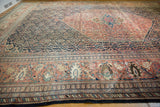 Antique Farahan Sarouk border with oversized terra cotta palmettes and navy field patterns.