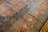 Intricate, time-softened terra cotta and navy palmettes on an antique Farahan Sarouk.