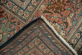 Antique Farahan Sarouk rug corner showing terra cotta and navy patterns, low pile, and hand-knotted reverse.