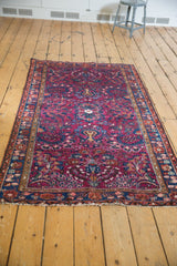 Vintage Lilihan rug, angled view of its intricate raspberry red floral vinery and low pile.