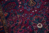Vintage Lilihan rug's low pile with visible knot heads, dark raspberry and blue floral pattern.