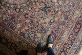 Vintage Meshed rug detail: floral cross-sections, palmettes, and vinery in blush red, cobalt blue, ivory.