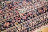 Blush red, cobalt blue, and ivory floral palmettes and vinery on vintage rug.
